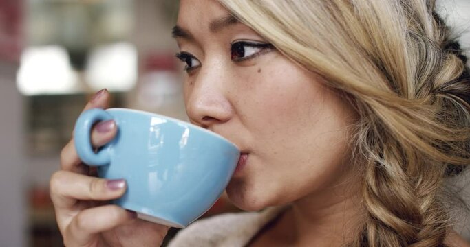Young woman, drinking coffee and thinking of ideas, inspiration or taste of espresso for customer review. Serious Asian person or food critic with tea, caffeine or beverage at cafe or restaurant
