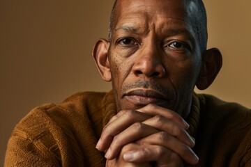 Portrait of a sad senior African American man on a brown background