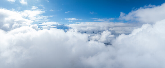 An aerial view over Verbier, Switzerland, reveals fluffy clouds blanketing the landscape, with...
