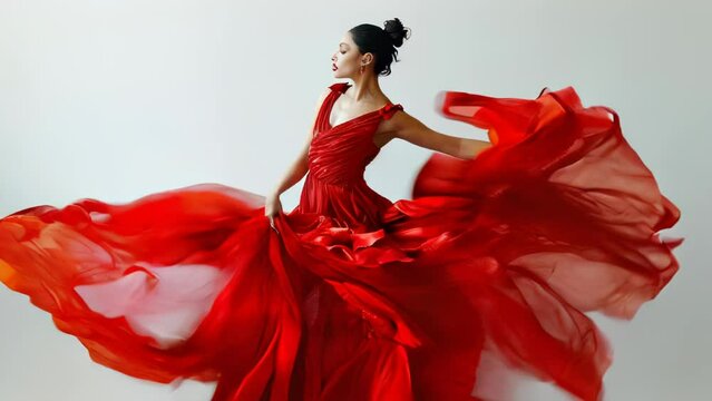 A passionate flamenco dancer wearing a fiery red dress performs a dynamic dance that blazes like flames. Her intense movements and expressions convey the soul she pours into dancing to the music. 