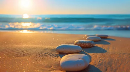 Foto op Aluminium A row of meticulously arranged pebbles on a sun-drenched beach, warmed by the golden light of dawn, against a backdrop of clear blue skies and gentle ocean waves. © ishtiaaq