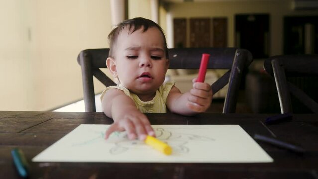 Baby child having fun painting a picture at home. Healthy childhood concept