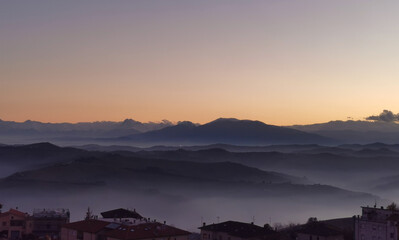 Le valli sotto alle montagne al tramonto come laghi di nebbia - obrazy, fototapety, plakaty