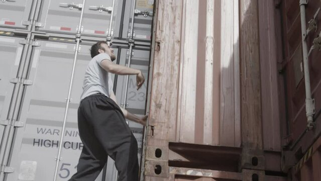 Man running and climbing on shipping containers