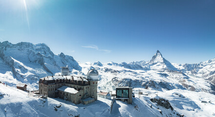 An aerial shot shows Zermatt, Switzerland's snowy scene, with a large dome building and the iconic...