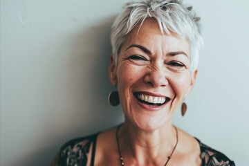 Portrait of a happy senior woman smiling against white wall. Toned. - obrazy, fototapety, plakaty
