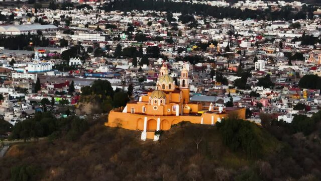 Telezoom drone shot circling the church on the Cholula Pyramid, sunset in Mexico