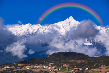 梅里雪山の急峻な霊峰に虹合成