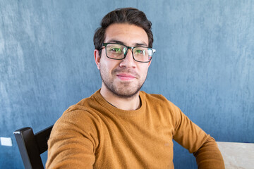 Joven apuesto con gafas tomándose una selfie