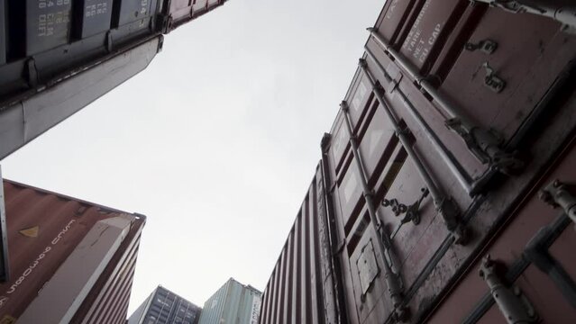 Cinematic steady cam shot between shipping containers as RC car jumps over them - slow motion