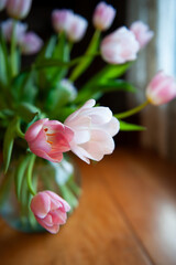 pink and white tulips in a glass vase