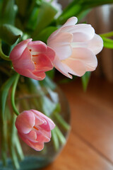 pink and white tulips in a glass vase