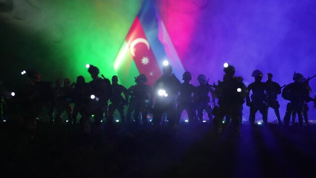 Azeri army concept. Silhouette of armed soldiers against Azerbaijani flag. Creative artwork decoration. Military silhouettes fighting scene dark toned foggy background. Selective focus