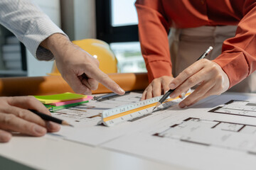 An engineer works with an architect to study the specifics of construction blueprints and use various tools to find the information, Compasses and rulers for design work