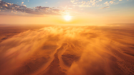 Sunset over a vast desert, with swirling sandstorms under a clear sky