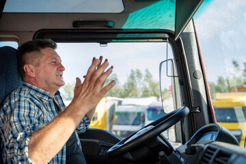 Nervous truck driver arguing with somebody in traffic, closeup shot, cursing  - obrazy, fototapety, plakaty