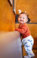 Happy and smiling baby boy standing on a couch