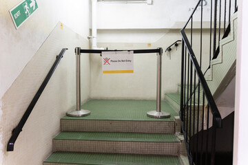 The rope barrier on staircase, Emergency exit sign and warning sign