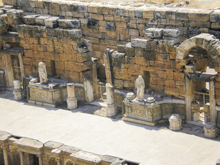 Stone ruins of an amphitheater scene with stone statues in Hierapolis one of the largest ancient cities in Turkey