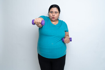 Naklejka premium Overweight fat indian woman exercising with dumbbells. isolated over white background. Plus size female. Copy Space
