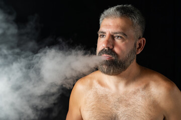Serious Middle-aged Man: Shirtless Vaper with Beard