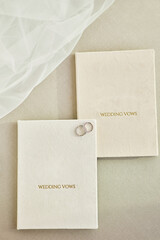 Elegant wedding rings rest on ‘WEDDING VOWS’ booklets