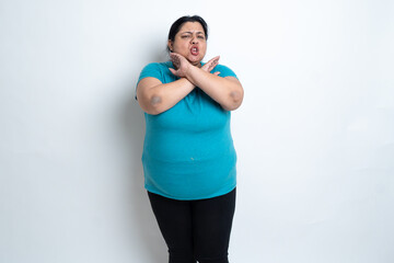 Overweight fat indian woman doing cross arms sign, saying no isolated over white background. Plus...