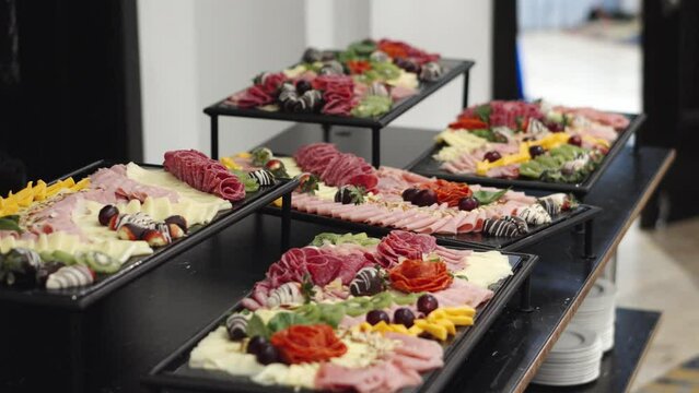 Charcuterie board with different fruits, cheeses and hams at a wedding or business banquet