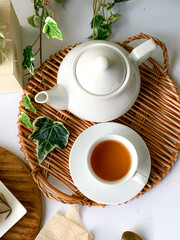 Top view of a cup of tea with teapot