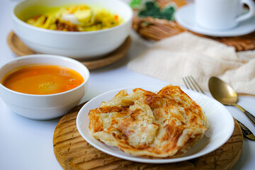 Roti Parata or Roti canai with curry sauce, a popular Malaysian breakfast