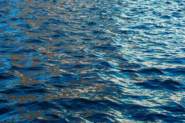 Deep sea waves. The surface of the blue sea has ripples and light reflecting on the sea.	