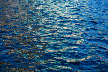 Deep sea waves. The surface of the blue sea has ripples and light reflecting on the sea.