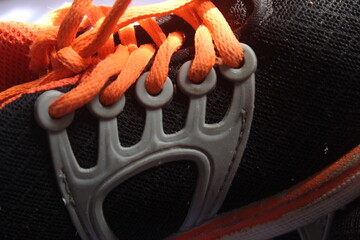 Cut out black sports shoes with orange laces. suitable for background and texture themes