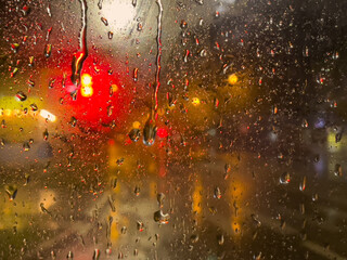Rain bokeh road lights. Abstract shot of evening city traffic bokeh. Multicolored lights of the...
