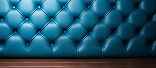 Detailed view of a textured blue leather wall contrasting with a smooth wooden floor in a room
