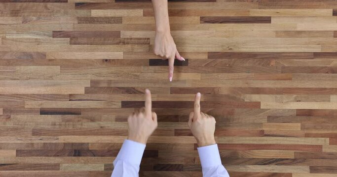 Pointing finger and discussing and arguing at a wooden table top view