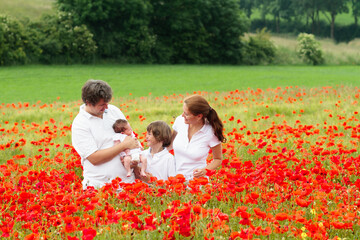 Fototapeta premium Family in poppy flower meadow
