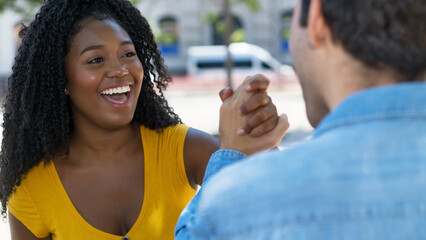 Pretty black female young adult giving high five to latin american friend