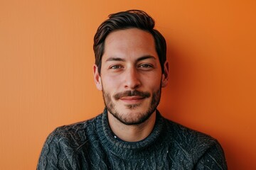 Portrait of a handsome young man with beard and mustache on orange background - obrazy, fototapety, plakaty