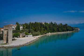 Sirmione, Lake Garda, Italy. Sirmione coastline aerial view. Reflections in the water in the background blue sky
