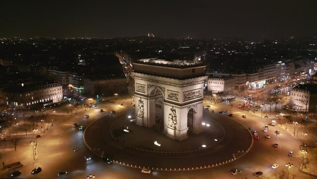 Triumphal arch at night and Paris cityscape, France. Aerial drone panoramic view