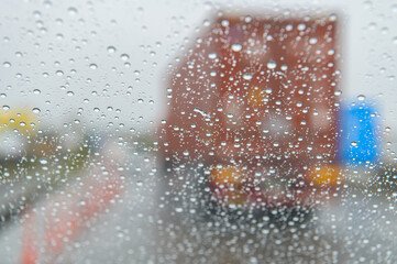 雨の日のフロントガラス越しに見たトラック