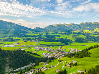 A scenic view of Hollersbach im Pinzgau with lush green fields and rolling hills under a clear sky. Hohe Tauern, Austria - 774637908