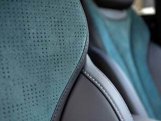 Part of leather car headrest seat details. Сlose-up black  and blue perforated leather car seat....