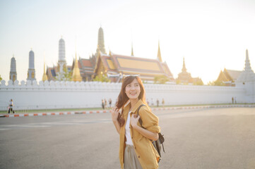 Traveler asian woman in her 30s, backpack slung over her shoulder, explores the intricate details...