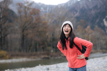 Tranquil climb, Asian woman in a pink fleece conquers Japan's peak. Elegant portrait by the lake,...