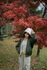 Asian woman in a charming dress revels in the colors of fall. A delightful and elegant portrait...