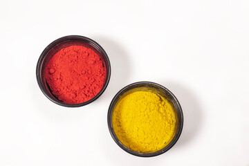 Red and yellow Holi powder colors in plastic box on white background for Indian festival Holi
