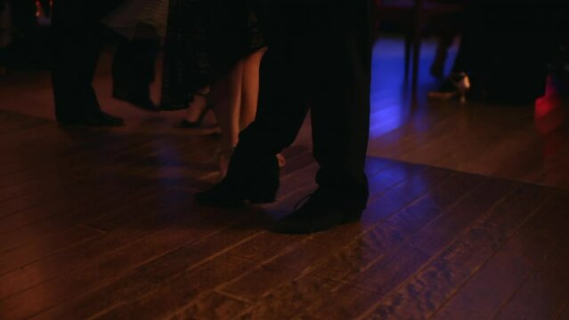 foot steps in the floor of a milonga dancing Argentine Tango in a moody bar cafe