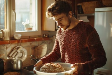 Man in a cozy kitchen enjoying the warmth of fresh bread - obrazy, fototapety, plakaty
